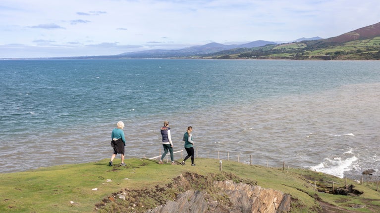 Walkers on the coastal path on Llyn Peninsula at Morfa and Nant Bach, Gwynedd